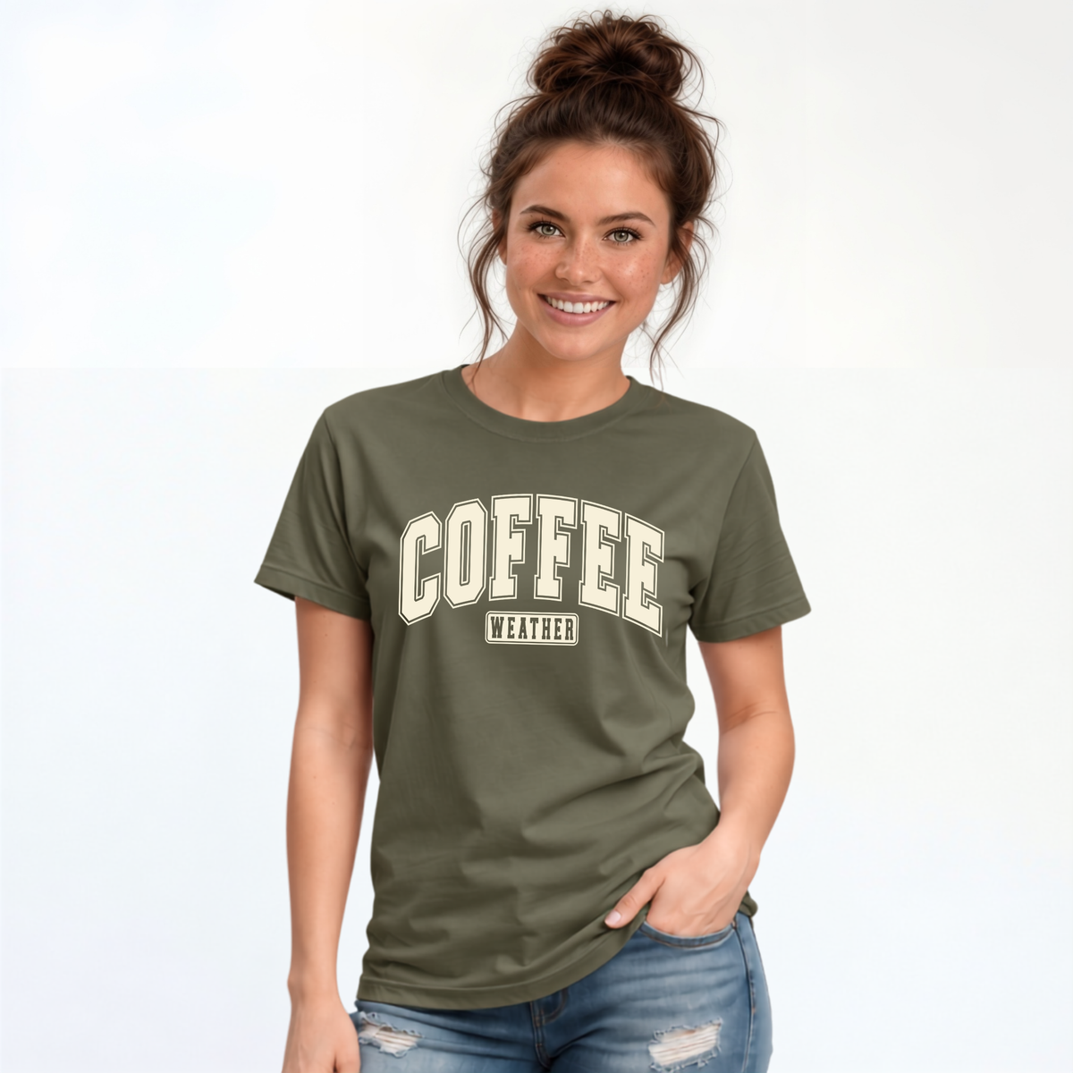 Woman wearing a military green T-shirt with "COFFEE WEATHER" printed in cream on the front against a white background.