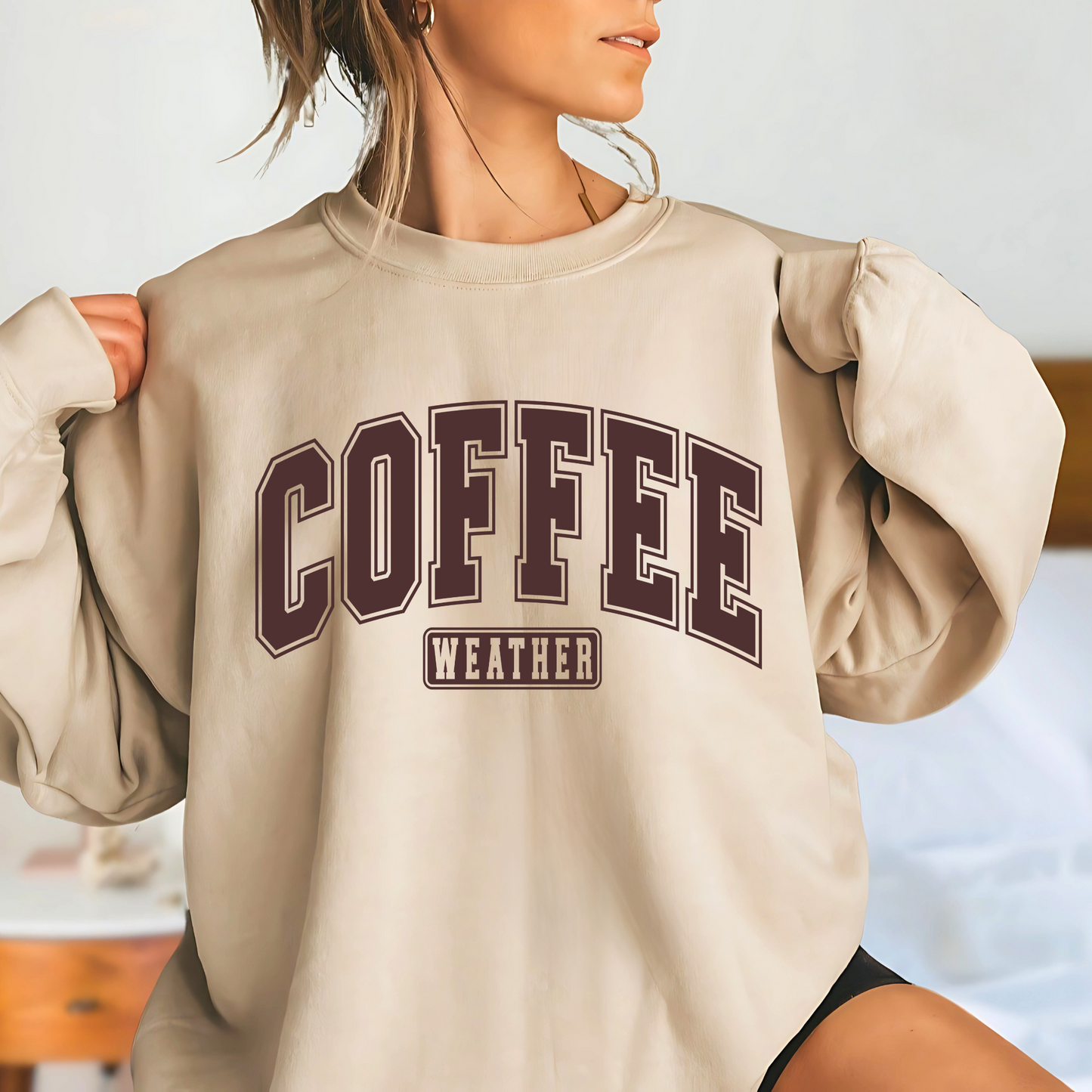 Woman in sand colored crewneck with brown “Coffee Weather” text, cozy fall vibe

