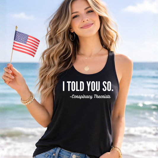 Woman wearing black racerback tank top with I Told You So quote holding American flag on beach, funny patriotic tank top for women summer outfit casual seaside lifestyle mockup