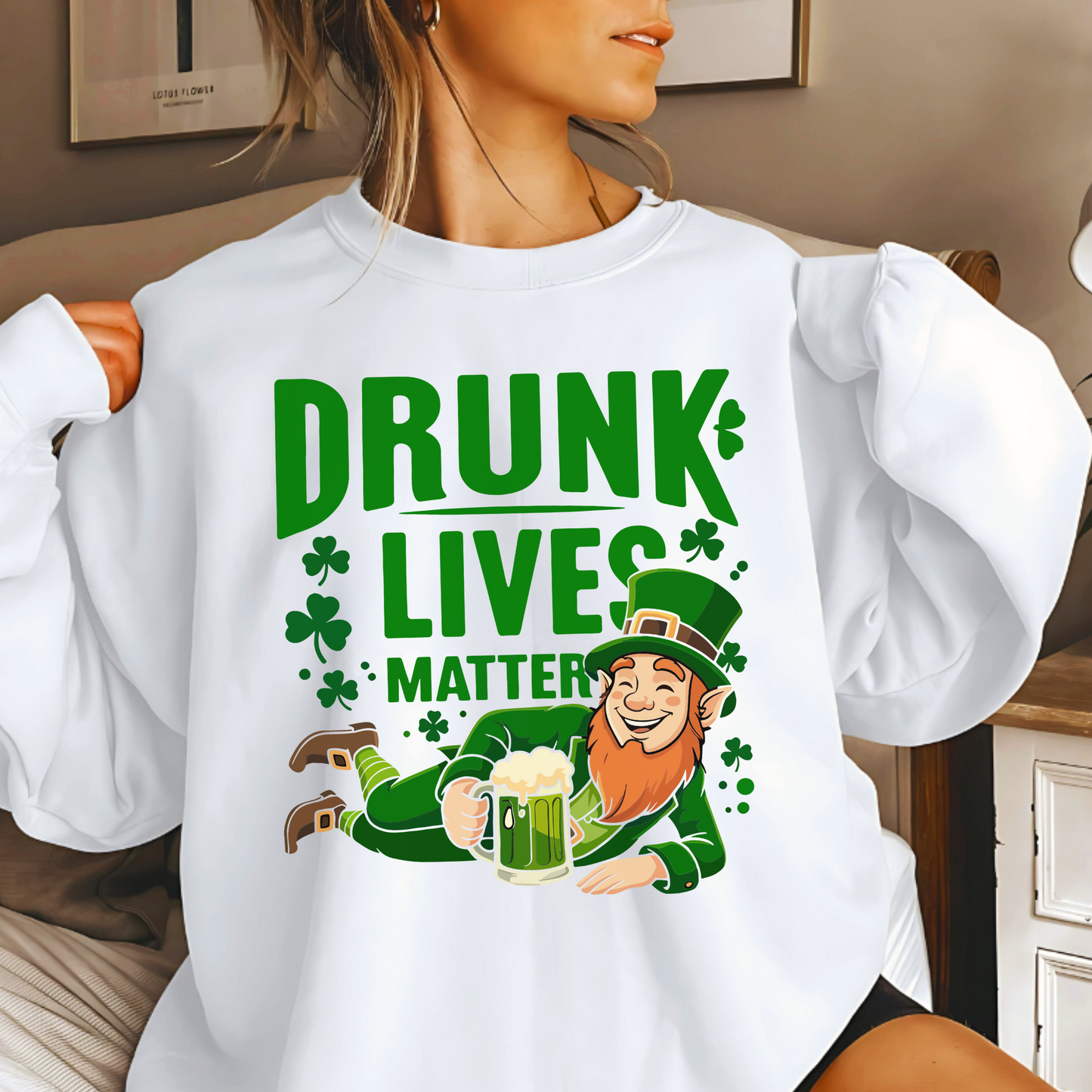 Woman modeling white “Drunk Lives Matter” sweatshirt with festive leprechaun and beer mug design for Irish holiday