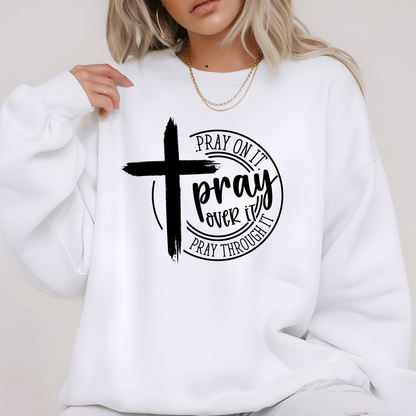 White sweatshirt with black cross and text design worn by a person.