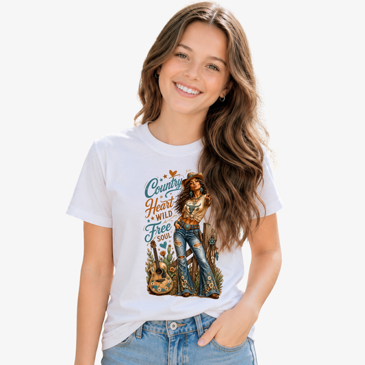 Youth model in a white T-shirt featuring the Country Heart Wild Free Soul cowgirl, guitar and rustic western graphic on a clean white background.