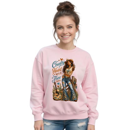 Woman modeling a light pink crewneck sweatshirt with the Country Heart Wild Free Soul cowgirl artwork on a bright white background.