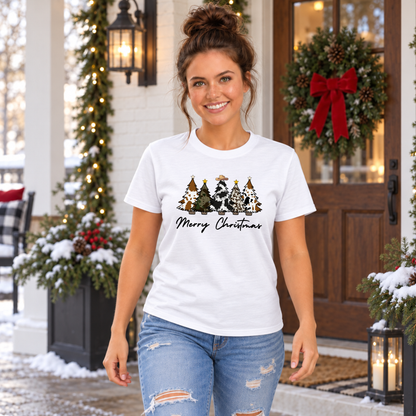 Woman wearing a white Merry Christmas cow print trees T-shirt outside a decorated doorway.