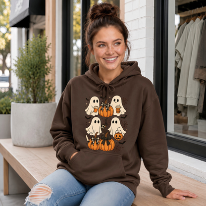 A woman wearing a brown pullover hoodie with a Halloween graphic of cartoon ghosts and pumpkins, paired with blue jeans, against a plain white background.