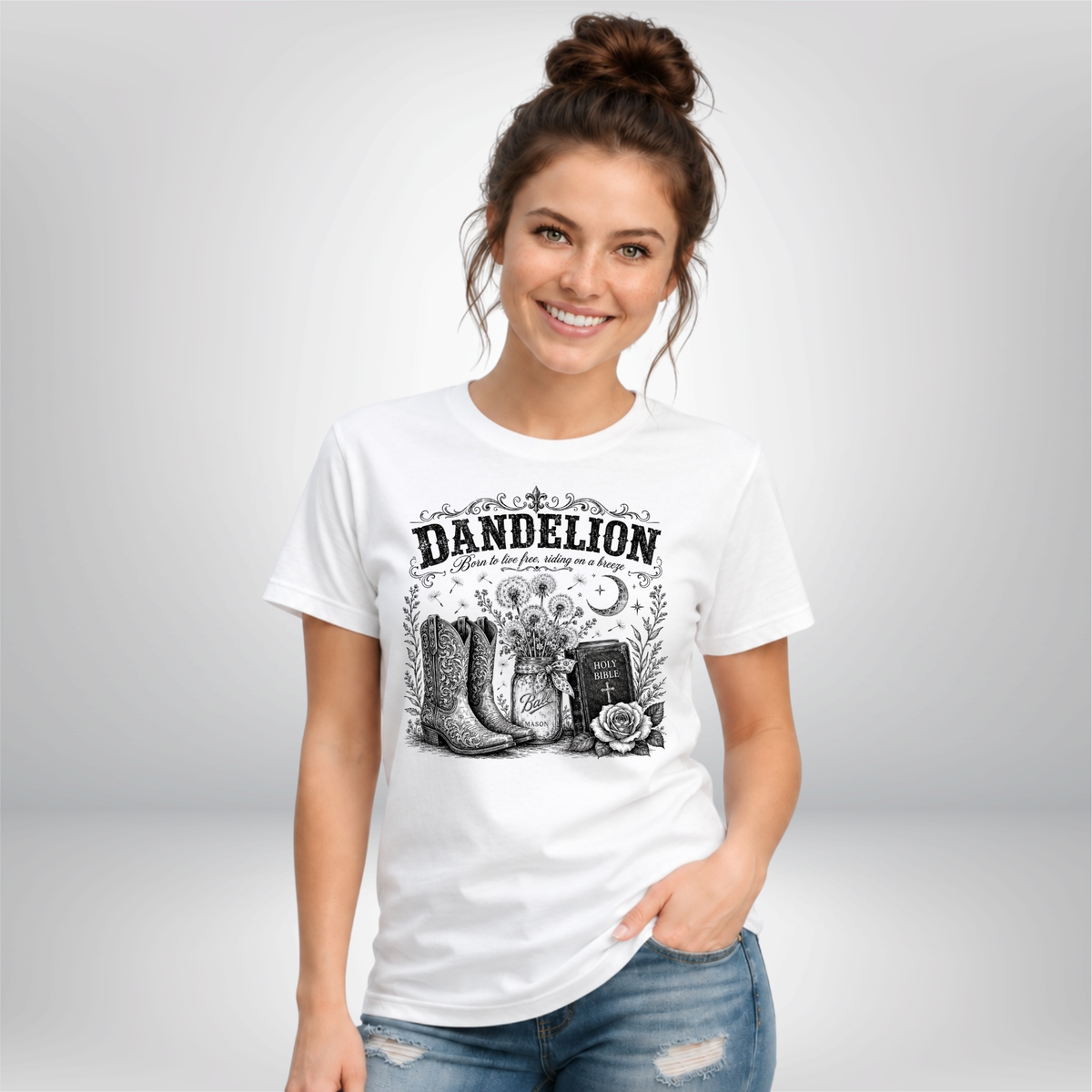Woman wearing a white Dandelion T-shirt with cowboy boots, dandelion-filled mason jar, Holy Bible, rose, and crescent moon graphic on a white background
