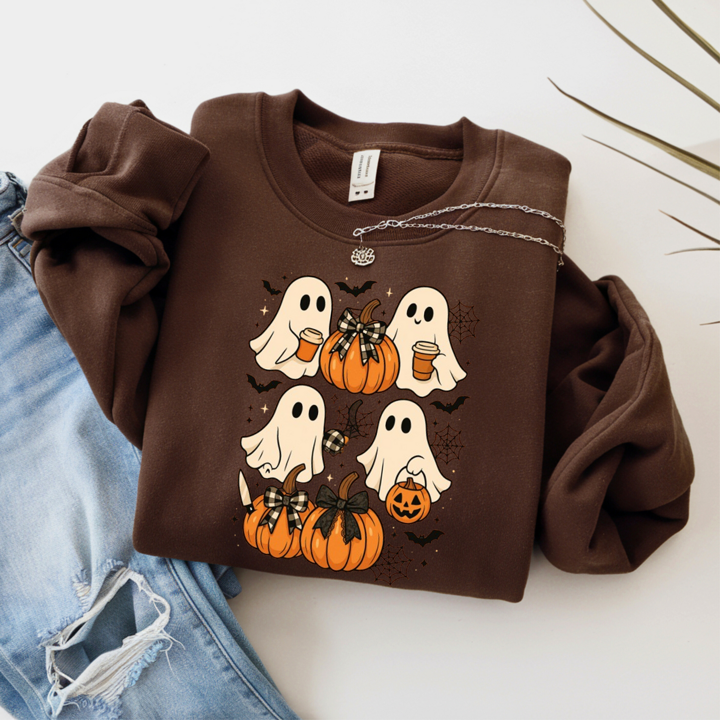 Dark brown Halloween ghost sweatshirt with pumpkin and cobweb print. Perfect cozy crewneck for spooky season, fall activities, and Halloween gatherings.