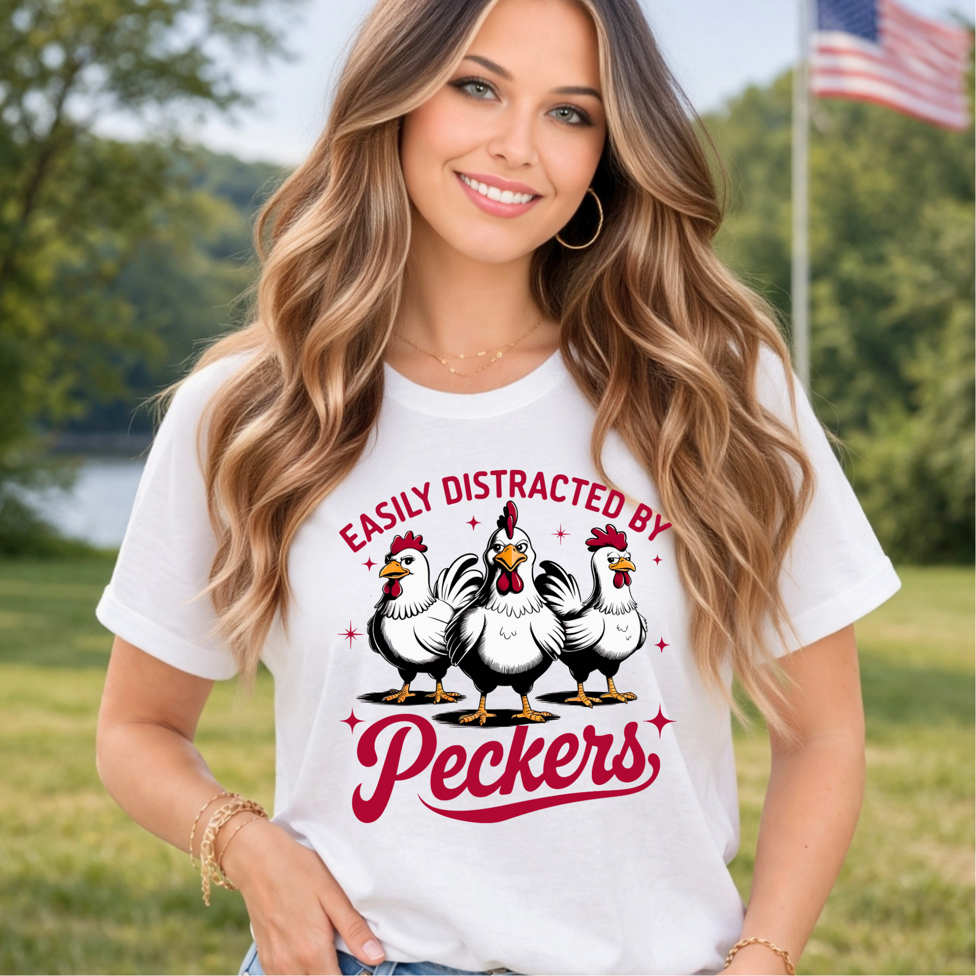 Woman wearing a white t-shirt with a graphic of chickens and text in an outdoor setting.