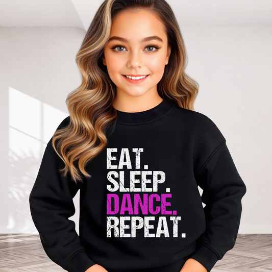 Girl wearing black youth dance sweatshirt with bold “Eat Sleep Dance Repeat” design in white and pink, cute kids dancer crewneck for practice or recitals.
