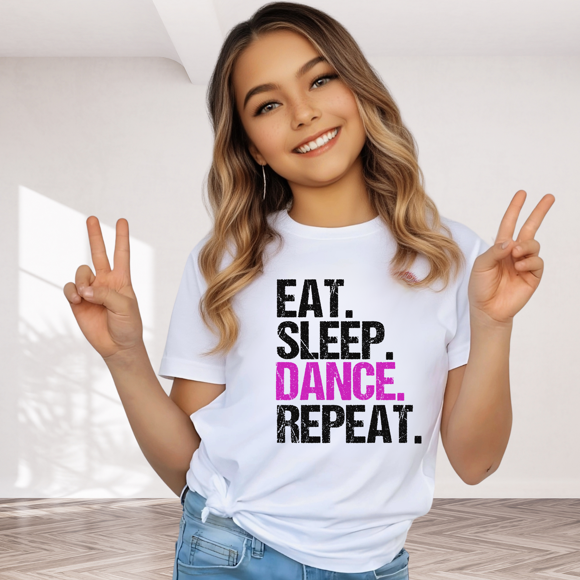 Girl wearing white youth dance t-shirt doing peace signs, featuring bold “Eat Sleep Dance Repeat” design, cute dancer shirt for girls and tweens.