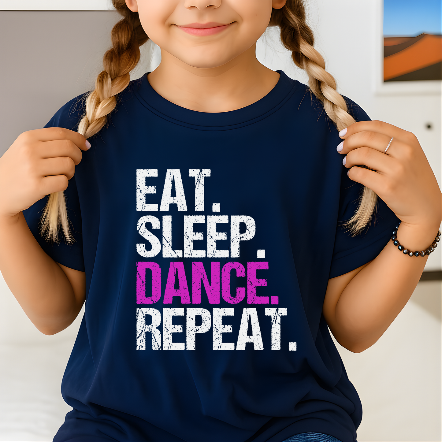 Child wearing a navy blue t-shirt with 'Eat. Sleep. Dance. Repeat.' text.