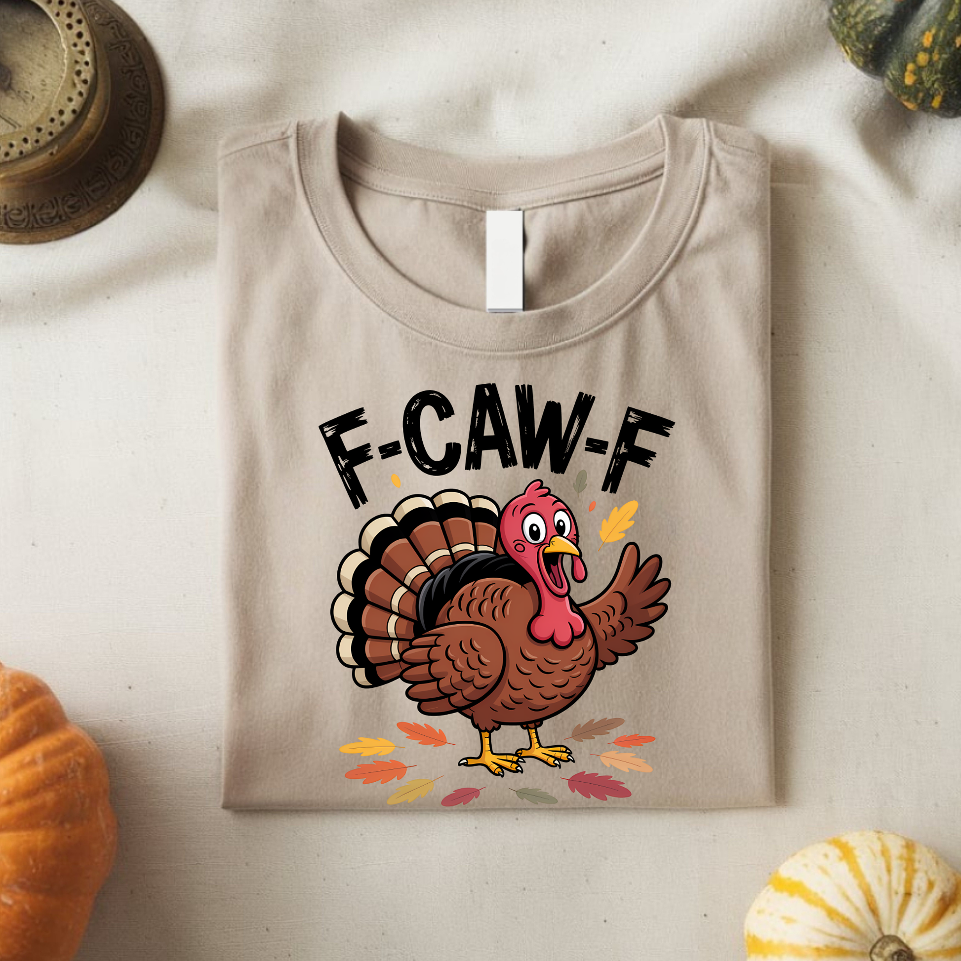 Folded sand color F-CAW-F Thanksgiving shirt with cartoon turkey print