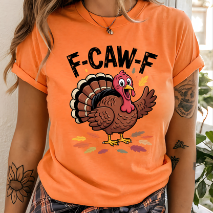 Woman wearing orange “F-CAW-F” turkey shirt, standing indoors with tattooed arm visible