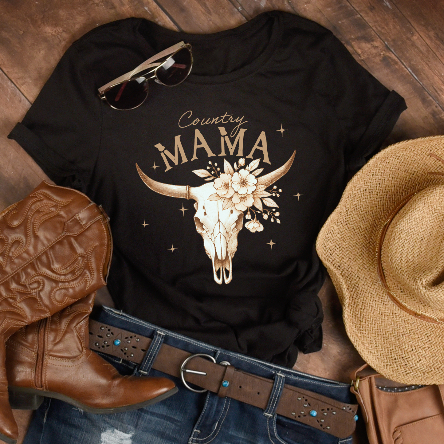 Flat lay of western “Country Mama” shirt styled with boots and cowboy hat. Rustic, rodeo-ready aesthetic perfect for country lovers.