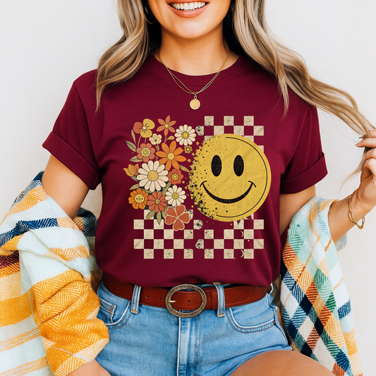 Maroon fall graphic tee with retro smiley face and checkered background

