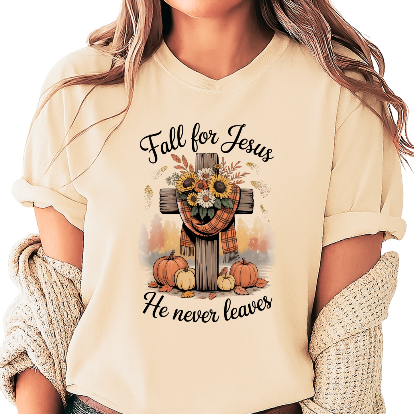 Person wearing a beige t-shirt with 'Fall for Jesus He never leaves' design featuring pumpkins and a cross.