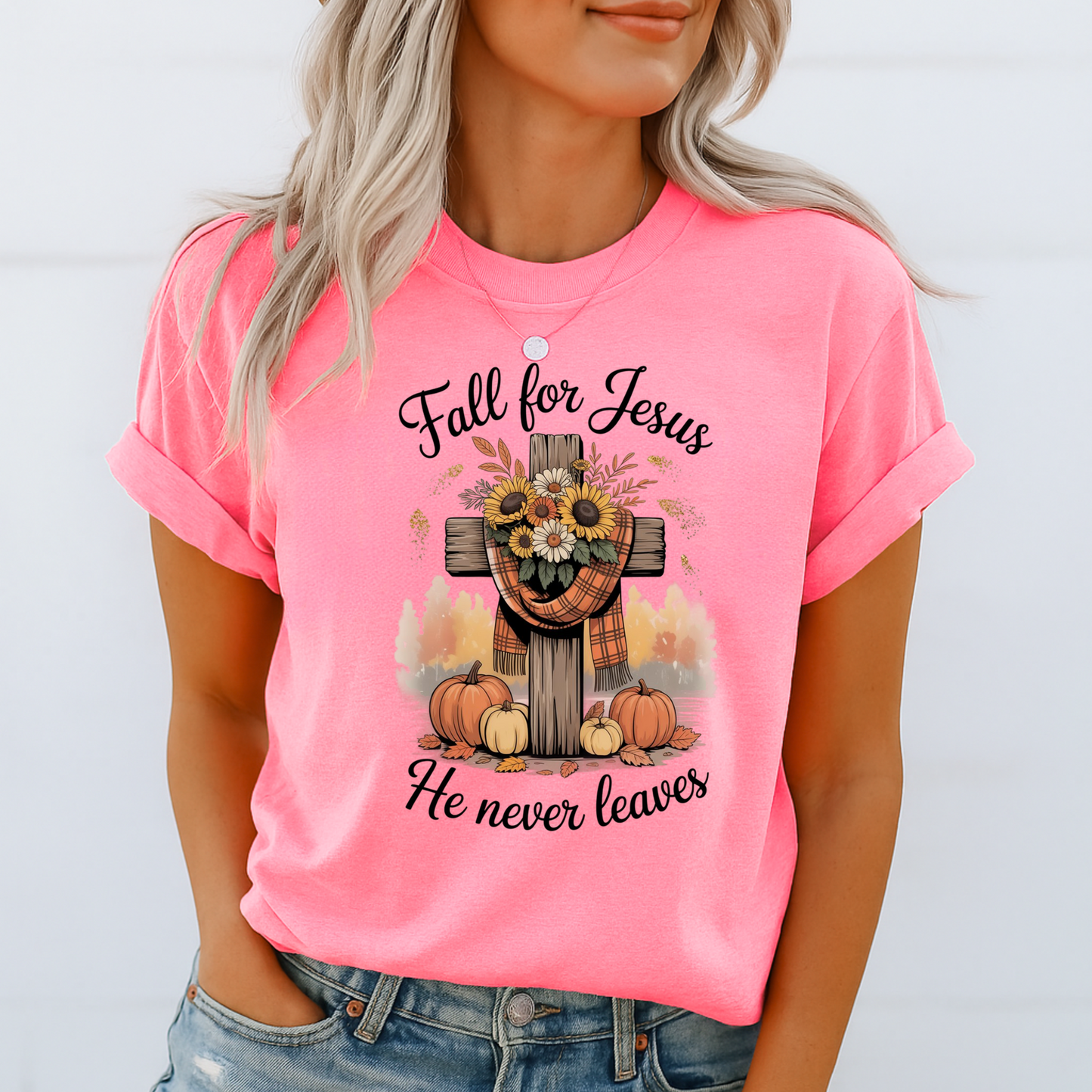 Person wearing a pink t-shirt with a fall-themed design and text.
