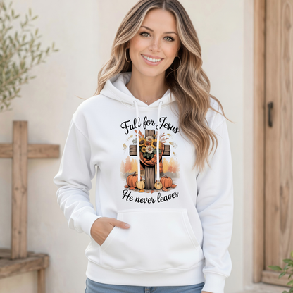 Woman wearing a white pullover hoodie with the Fall for Jesus He Never Leaves design featuring a cross, pumpkins, and autumn foliage.