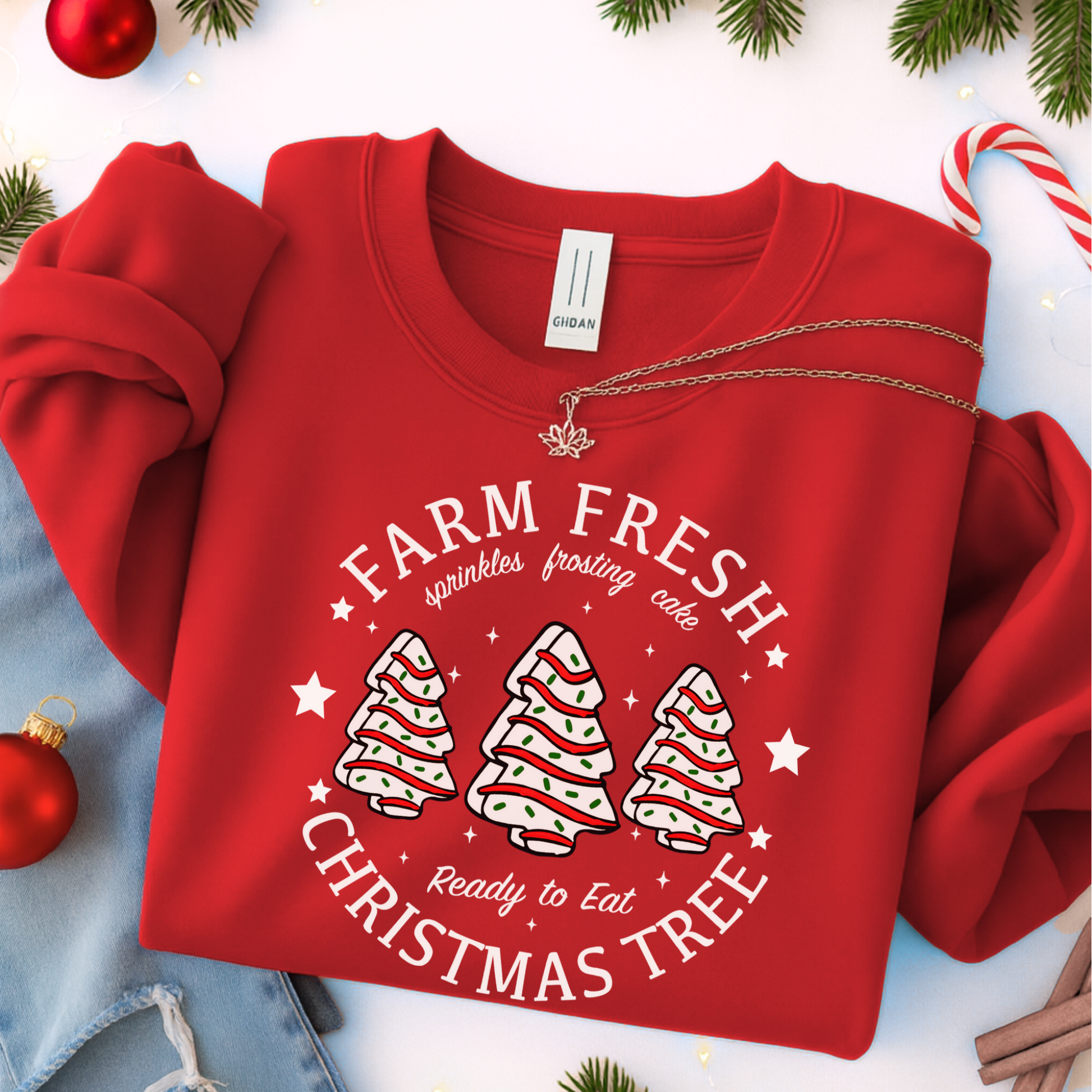 Red “Farm Fresh Christmas Trees” sweatshirt flat lay with pine accents