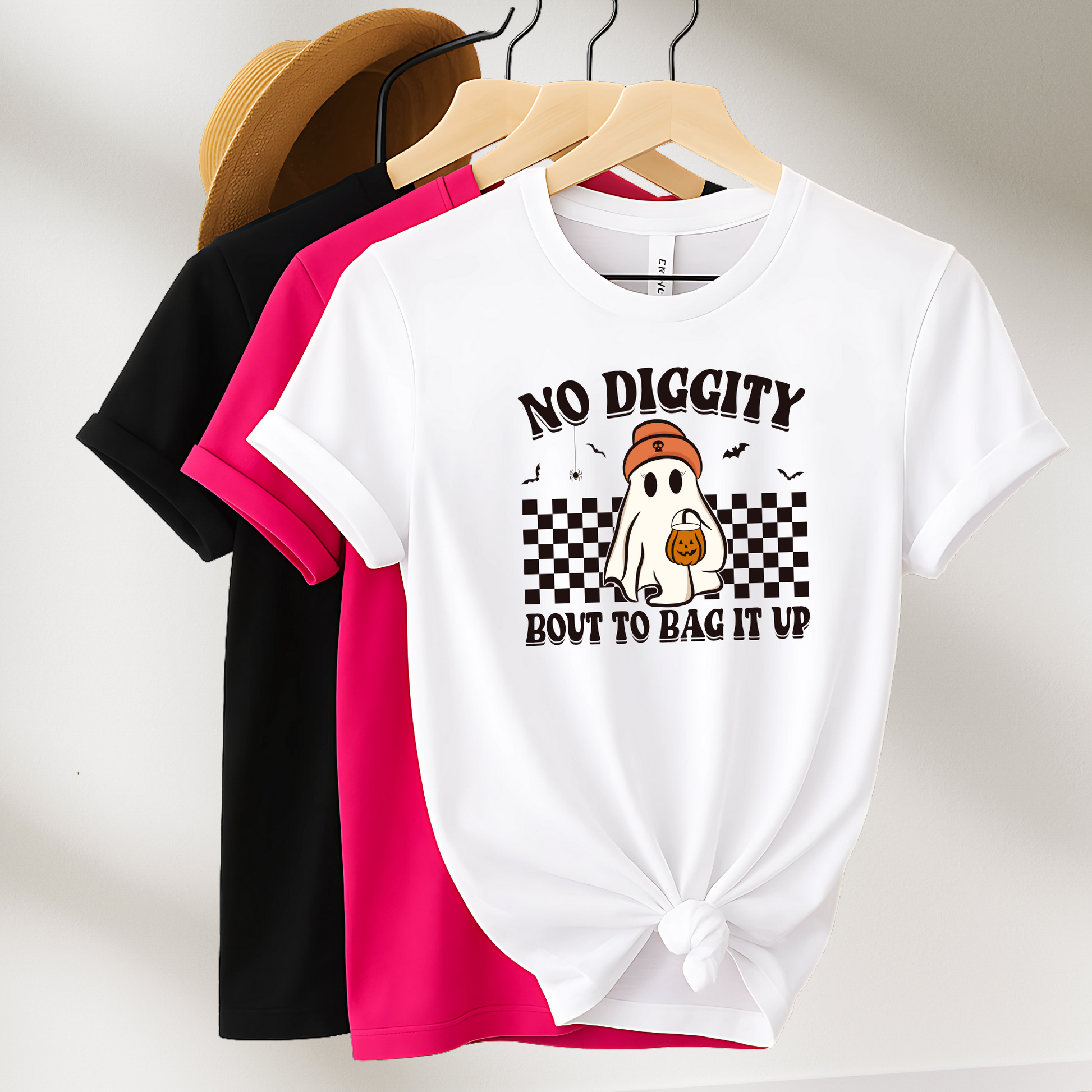 Flat lay of three graphic T-shirts in white, pink, and black featuring a fun ghost Halloween design. Available in adult and youth sizes.

