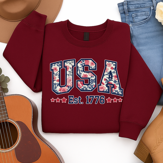 Flat lay of maroon USA Est. 1776 floral patriotic sweatshirt – perfect for 4th of July or fall fashion.

