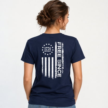 Back view of a woman wearing a navy T-shirt with a distressed white Free Since flag graphic and 1776 Patriot emblem