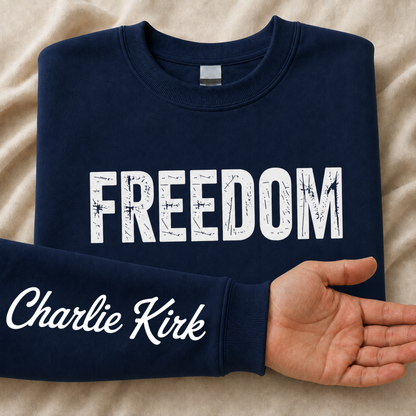 Navy FREEDOM crewneck sweatshirt flat lay with Charlie Kirk signature printed on the inside sleeve.