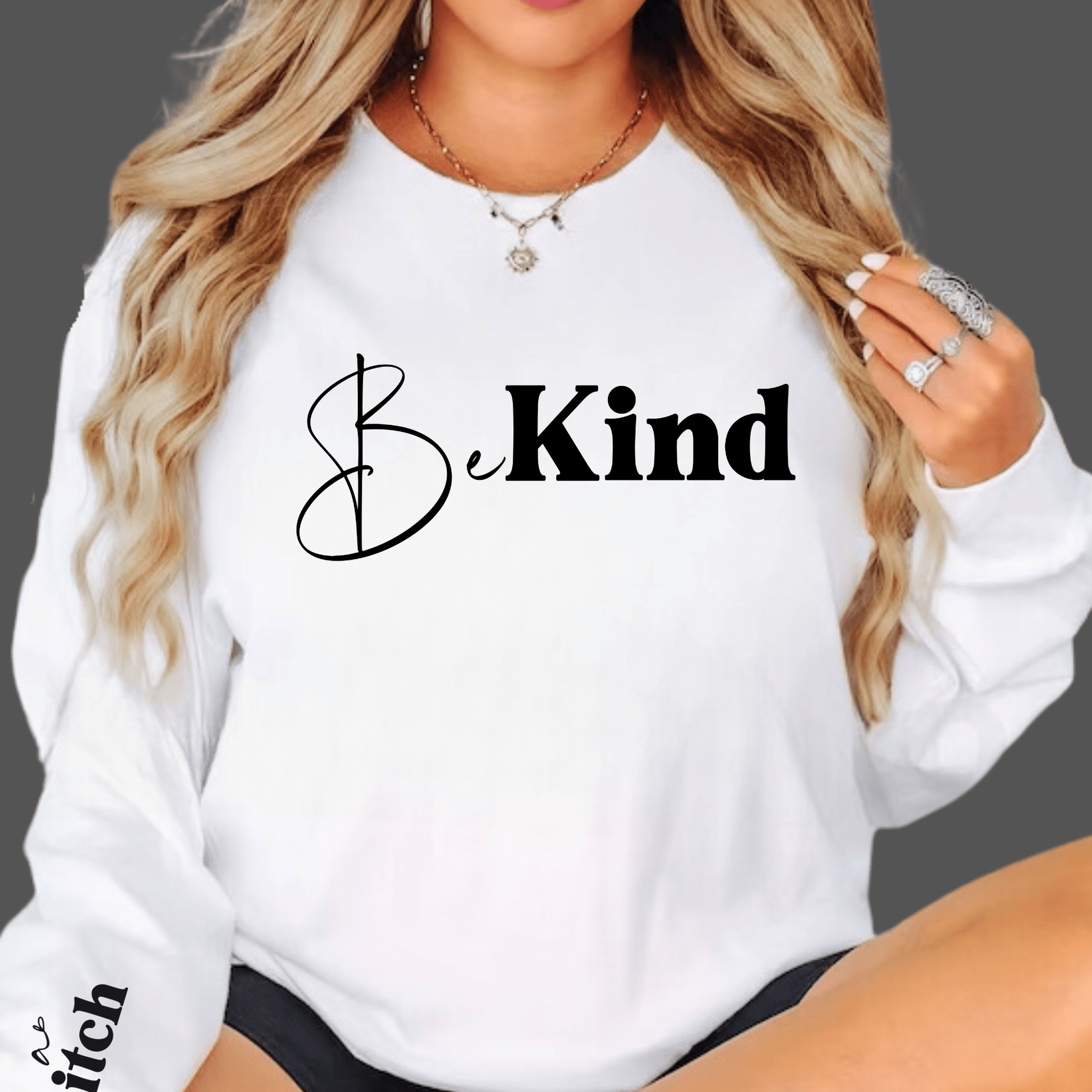 Funny White sweatshirt with 'Be Kind' text, worn by a person.