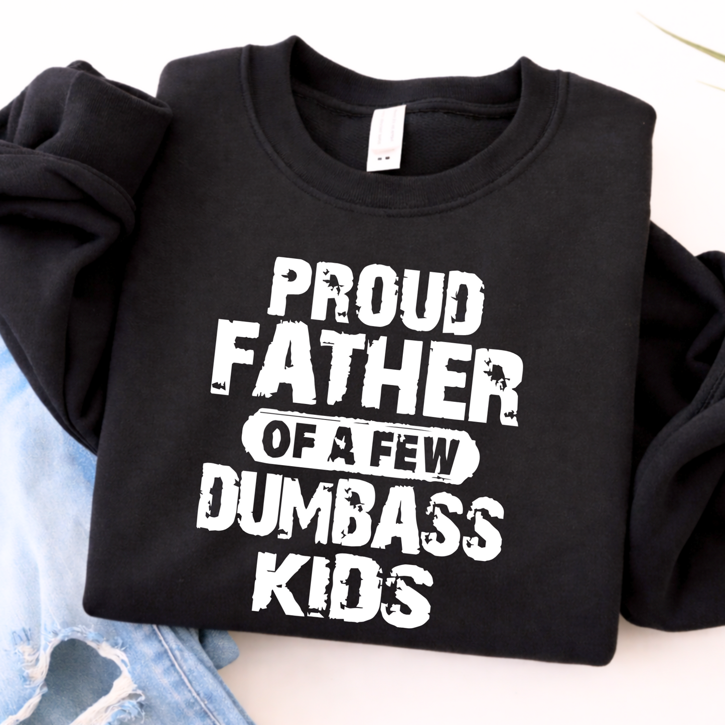 Black sweatshirt with white text 'Proud Father of a Few Dumbass Kids' on a light background.
