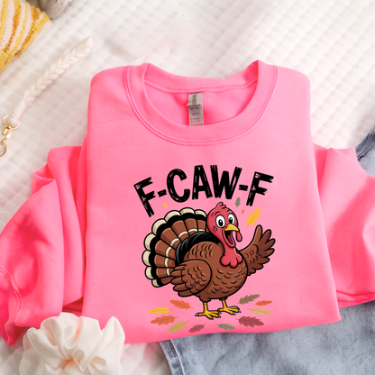 Bright pink sweatshirt folded with funny turkey graphic and fall leaves