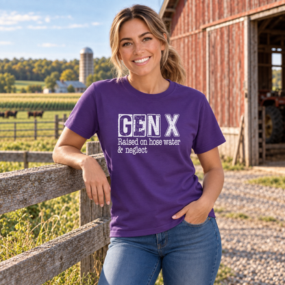 Woman in a purple GEN X Raised on hose water & neglect T-shirt leaning against a farm fence.
