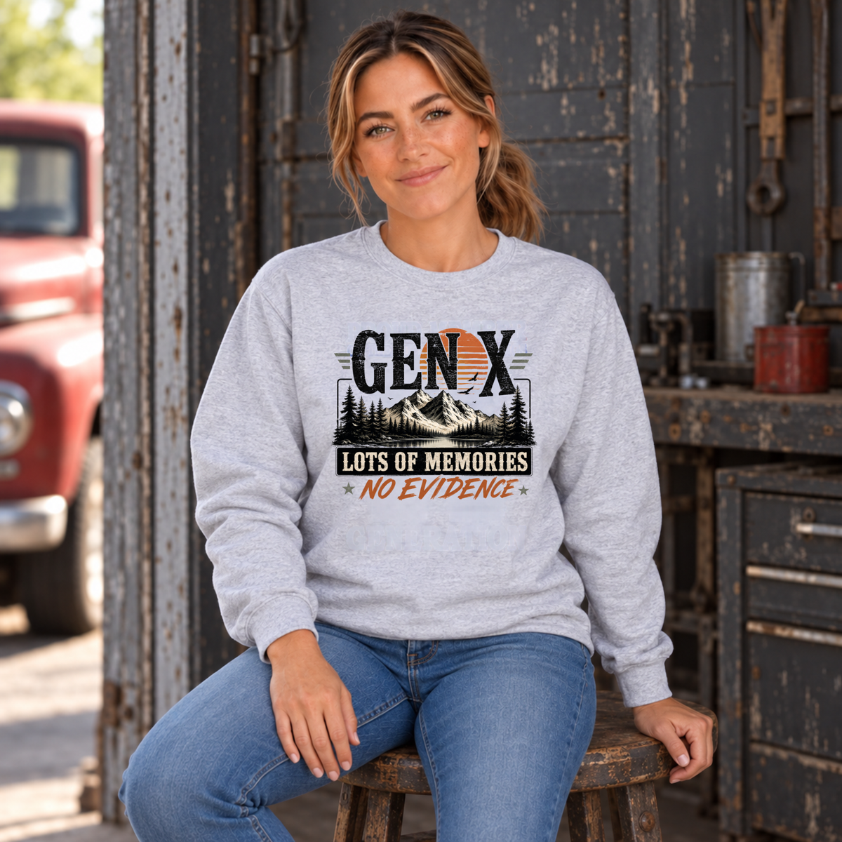 Women's sports gray Gen X sweatshirt with Lots of Memories No Evidence mountain design, modeled seated in a vintage workshop