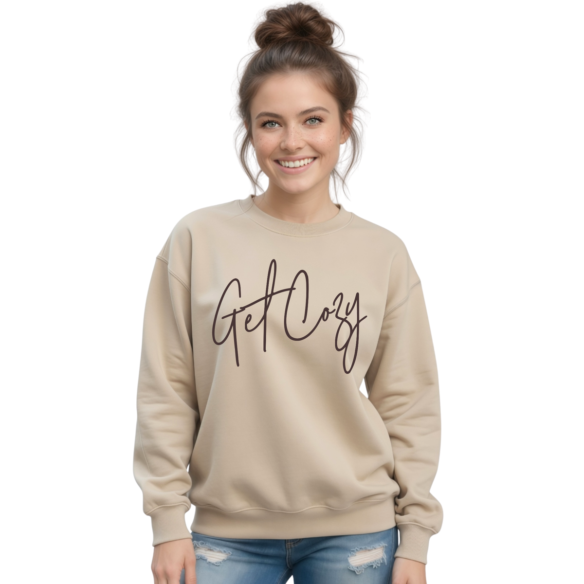 Woman wearing a sand crewneck sweatshirt with a minimalist Get Cozy script design, paired with blue jeans on a white background.