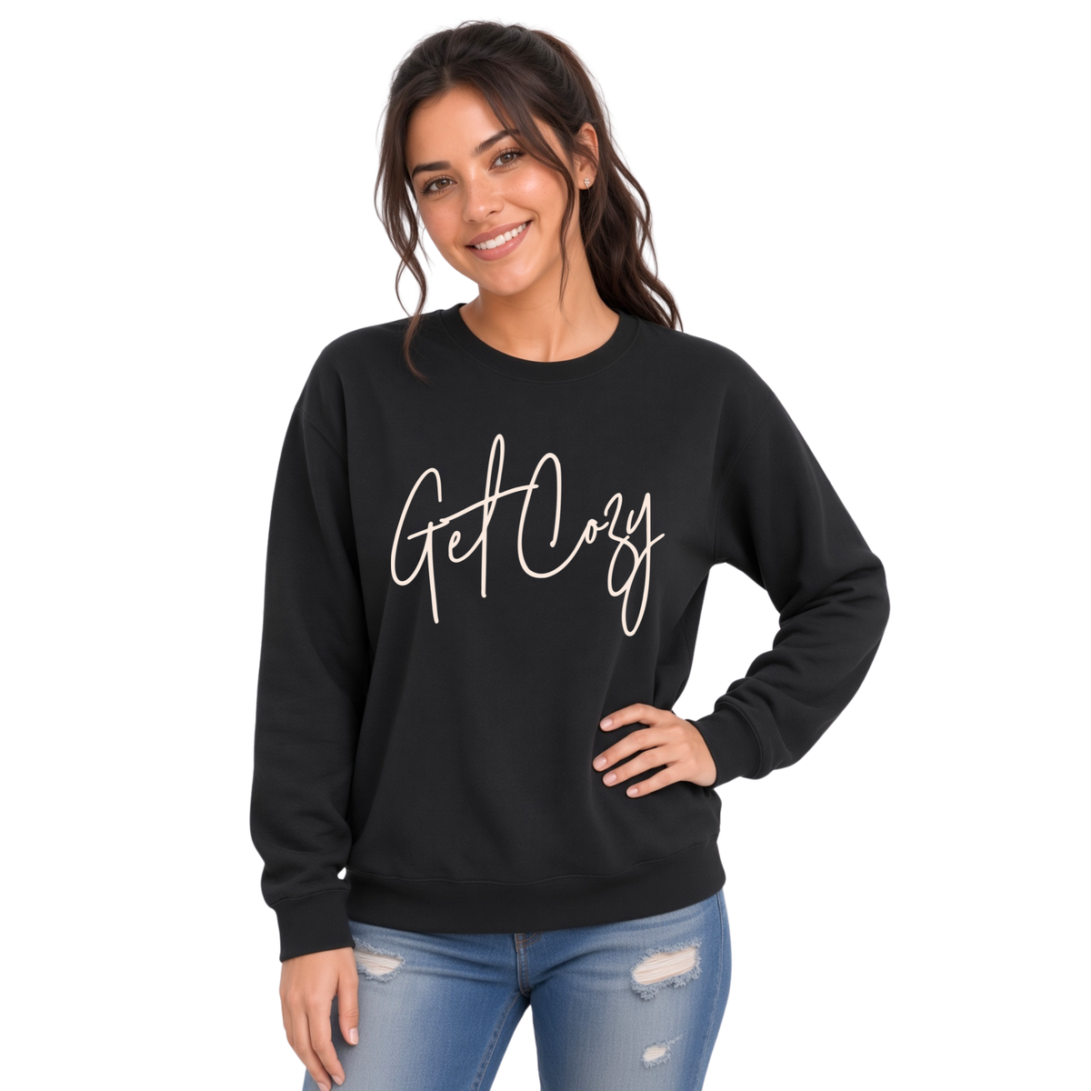Woman wearing a black crewneck sweatshirt with a minimalist Get Cozy script design, paired with distressed blue jeans on a white background.