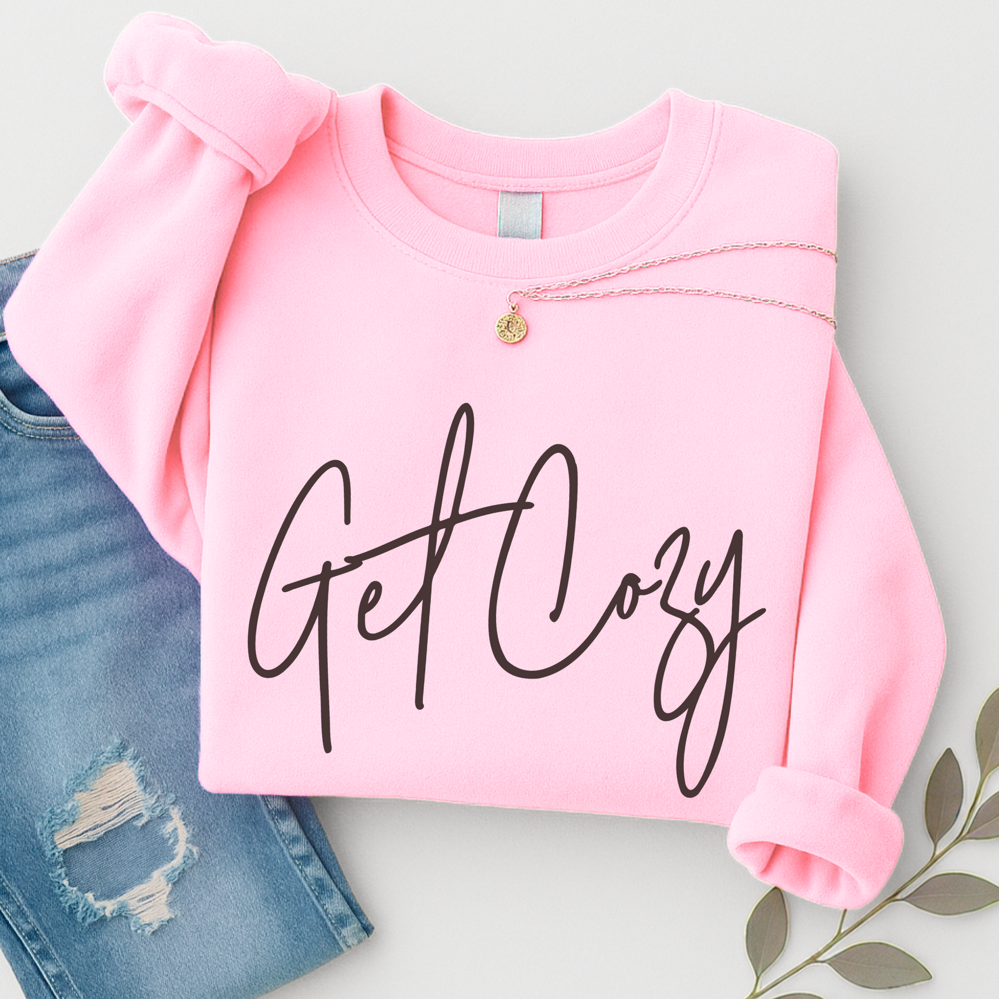 Pink fall sweatshirt with 'Get Cozy' text on a light gray background