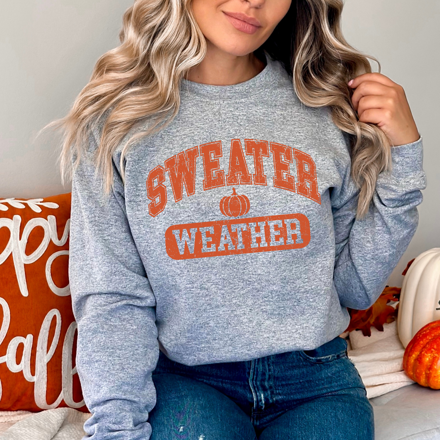 Girl in Gray “Sweater Weather” shirt sitting with fall leaves – kids fall outfit