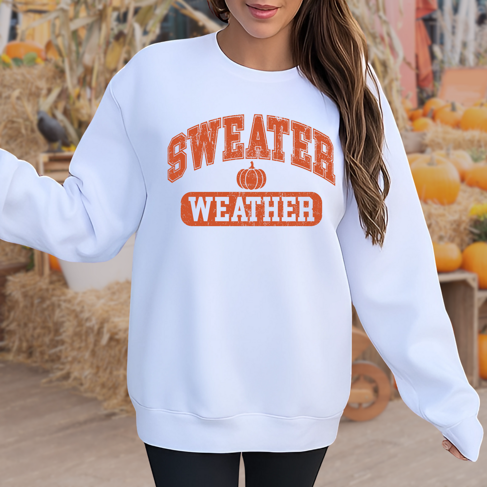 Girl in white “Sweater Weather” shirt sitting with fall leaves – kids fall outfit
