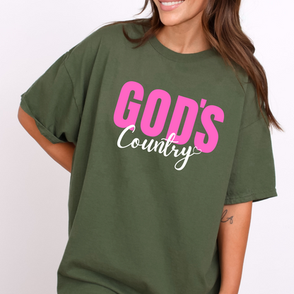 Green God's Country Christian T-shirt with pink and white text, perfect for patriotic believers who love faith-based apparel