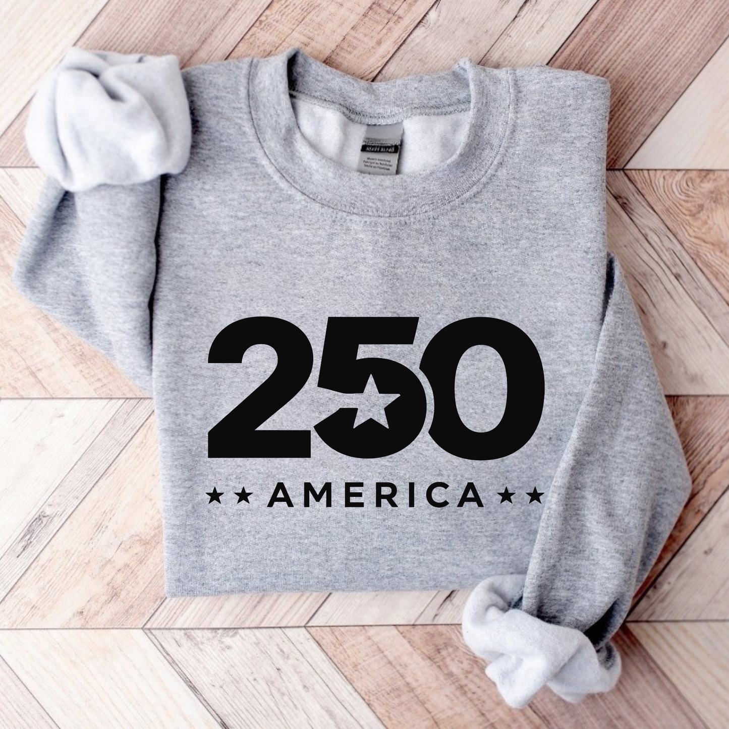 Gray sweatshirt with '250 America' print on a wooden floor