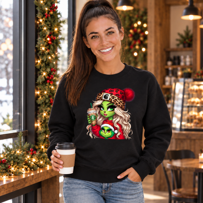 Woman holding a coffee cup in a holiday cafe wearing a black sweatshirt with the Boujee Green Girl Christmas design