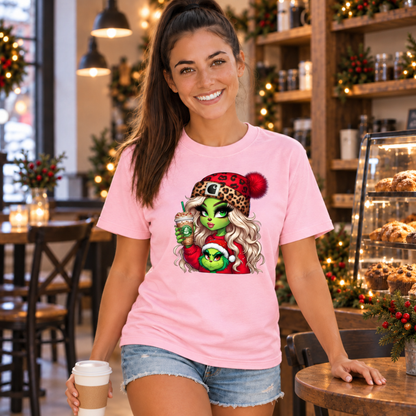Woman holding a takeaway coffee in a light pink T-shirt with the Boujee Green Girl Christmas design