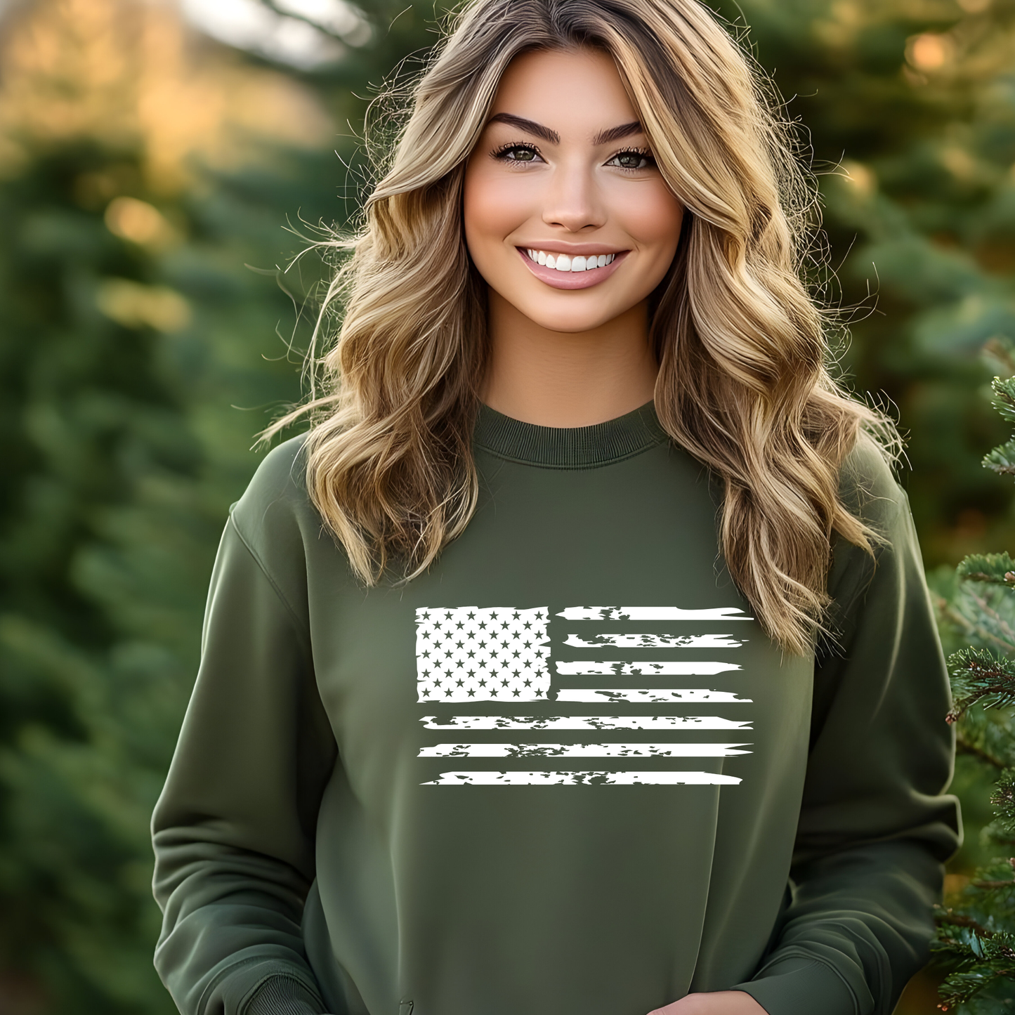 Woman wearing a green sweatshirt with a white flag design, standing outdoors with trees in the background.