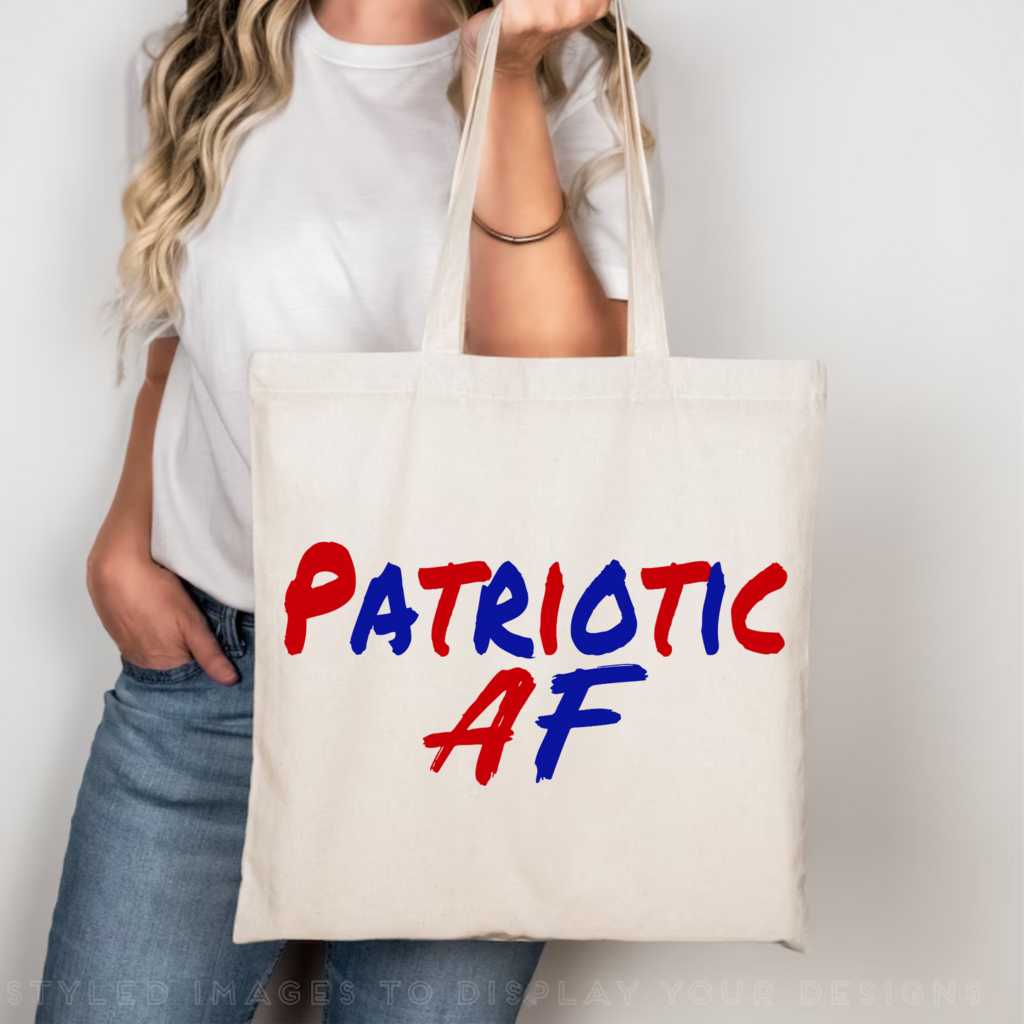 Woman holding natural canvas Patriotic AF tote bag in bright room