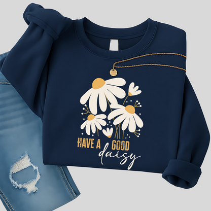 Navy blue floral sweatshirt with daisy graphic folded with distressed jeans and necklace, styled for cool fall days—great for casual outings, coffee runs, and relaxed fall fashion.
