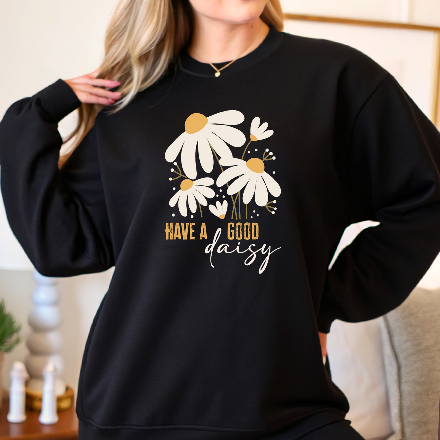 Woman modeling black daisy crewneck sweatshirt indoors, styled casually for fall with a soft relaxed fit—great for layering or lounging in cozy, seasonal comfort.v