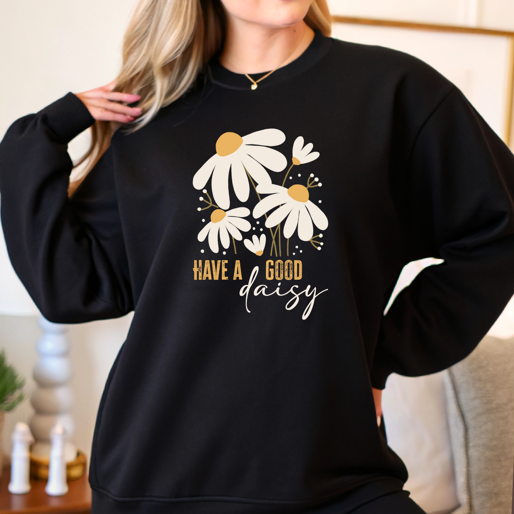 Woman modeling black daisy crewneck sweatshirt indoors, styled casually for fall with a soft relaxed fit—great for layering or lounging in cozy, seasonal comfort.v
