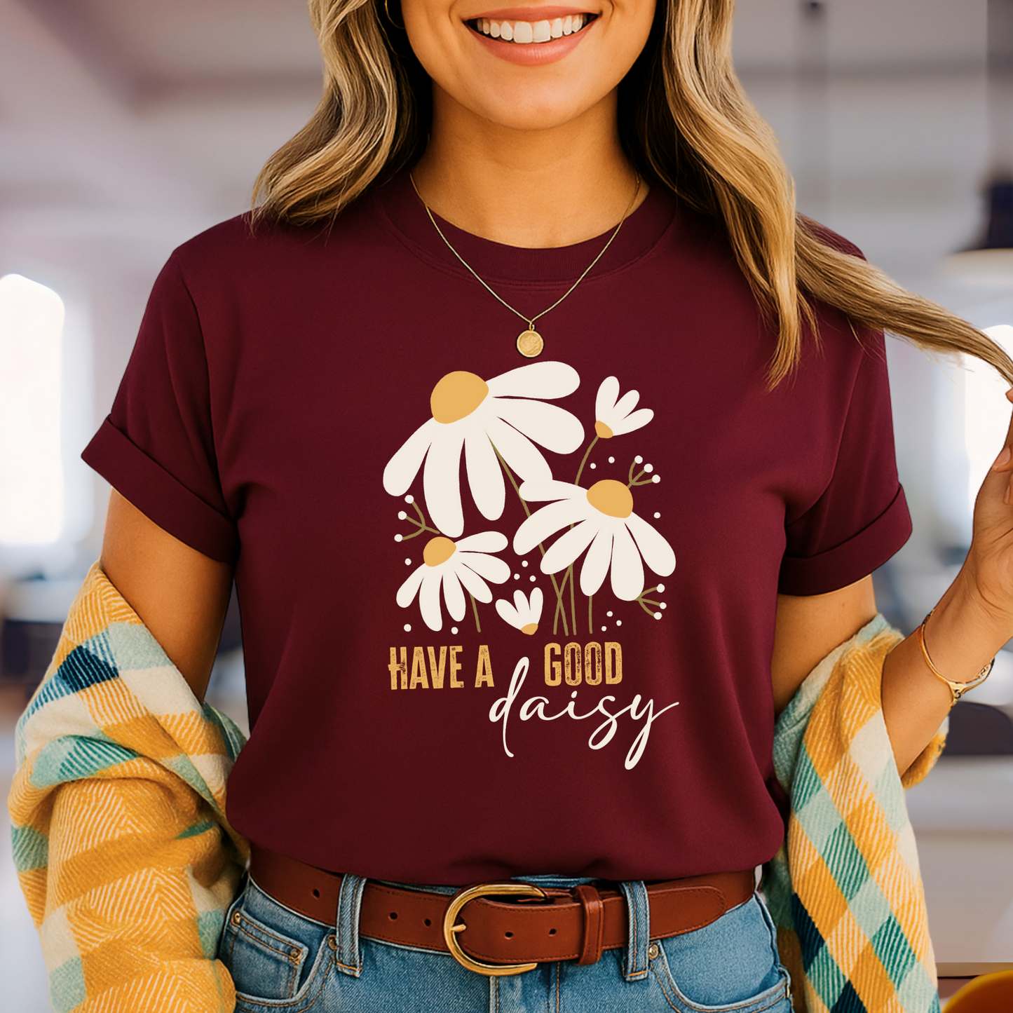 Maroon “Have a Good Daisy” T-shirt with white daisy graphic and retro lettering, styled for fall with warm tones and seasonal outfit layering.