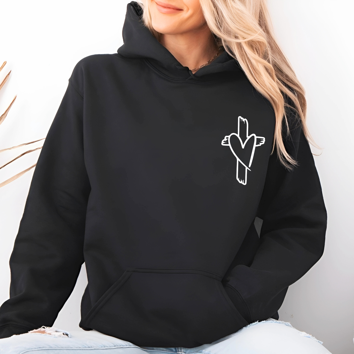 Person wearing a black hoodie with a white logo on a light background