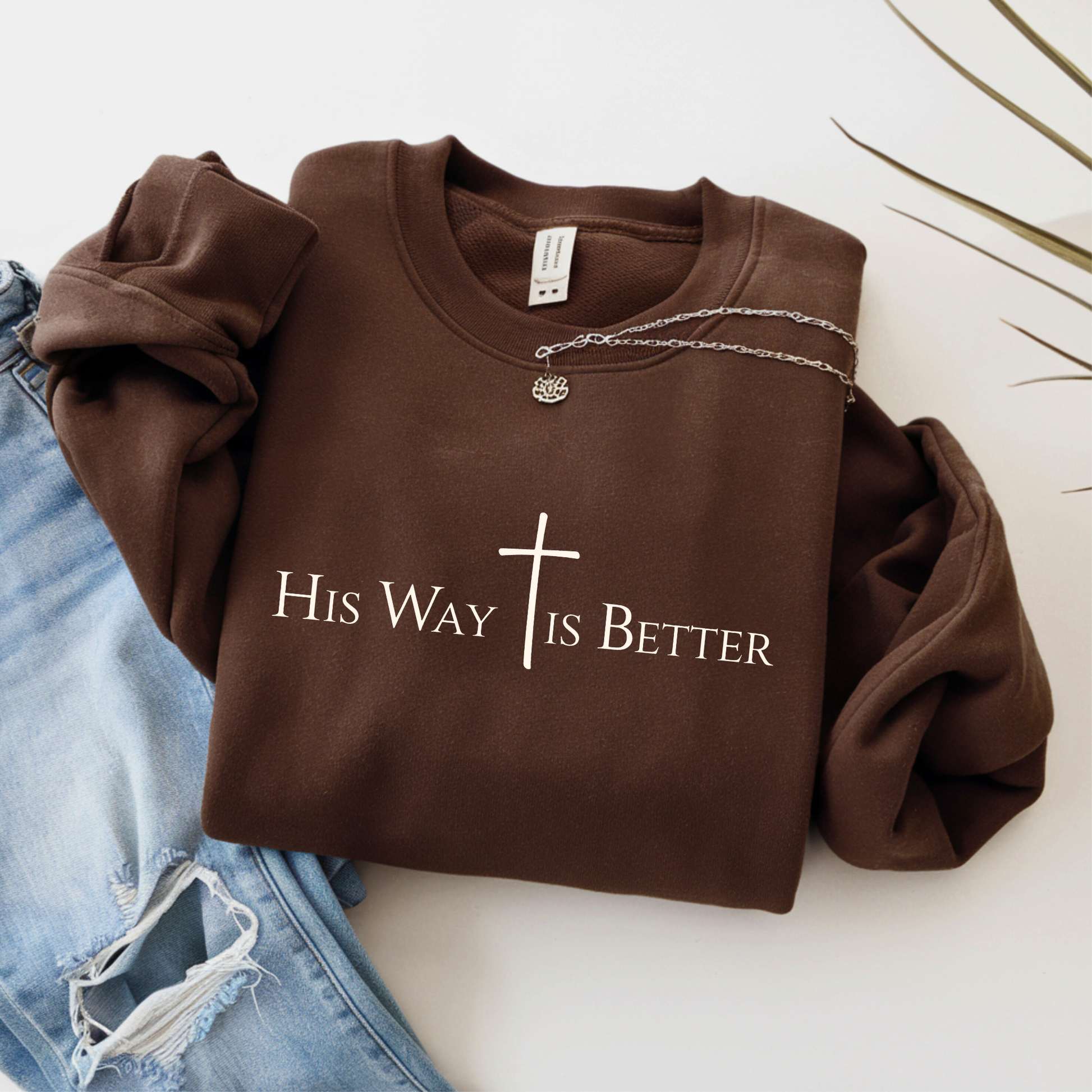 Brown sweatshirt with 'His Way is Better' text and cross on a white background