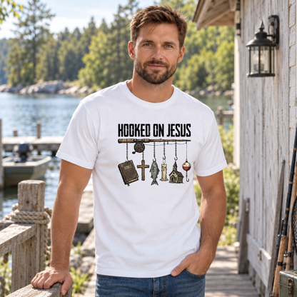 Man wearing a white Hooked on Jesus T-shirt beside a lake and wooden dock.